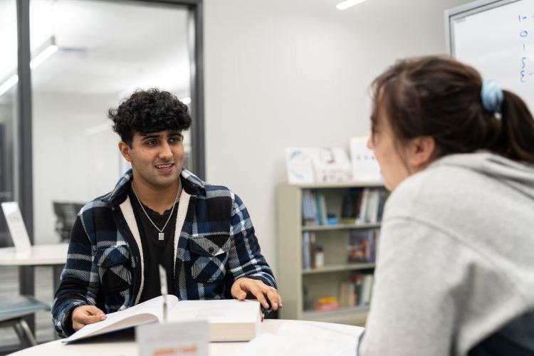 two students sitting at a table in the tutoring center